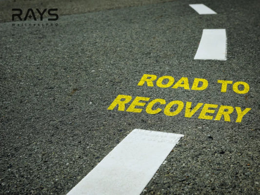 Yellow road to recovery sign painted on asphalt symbolizing health and wellness journey